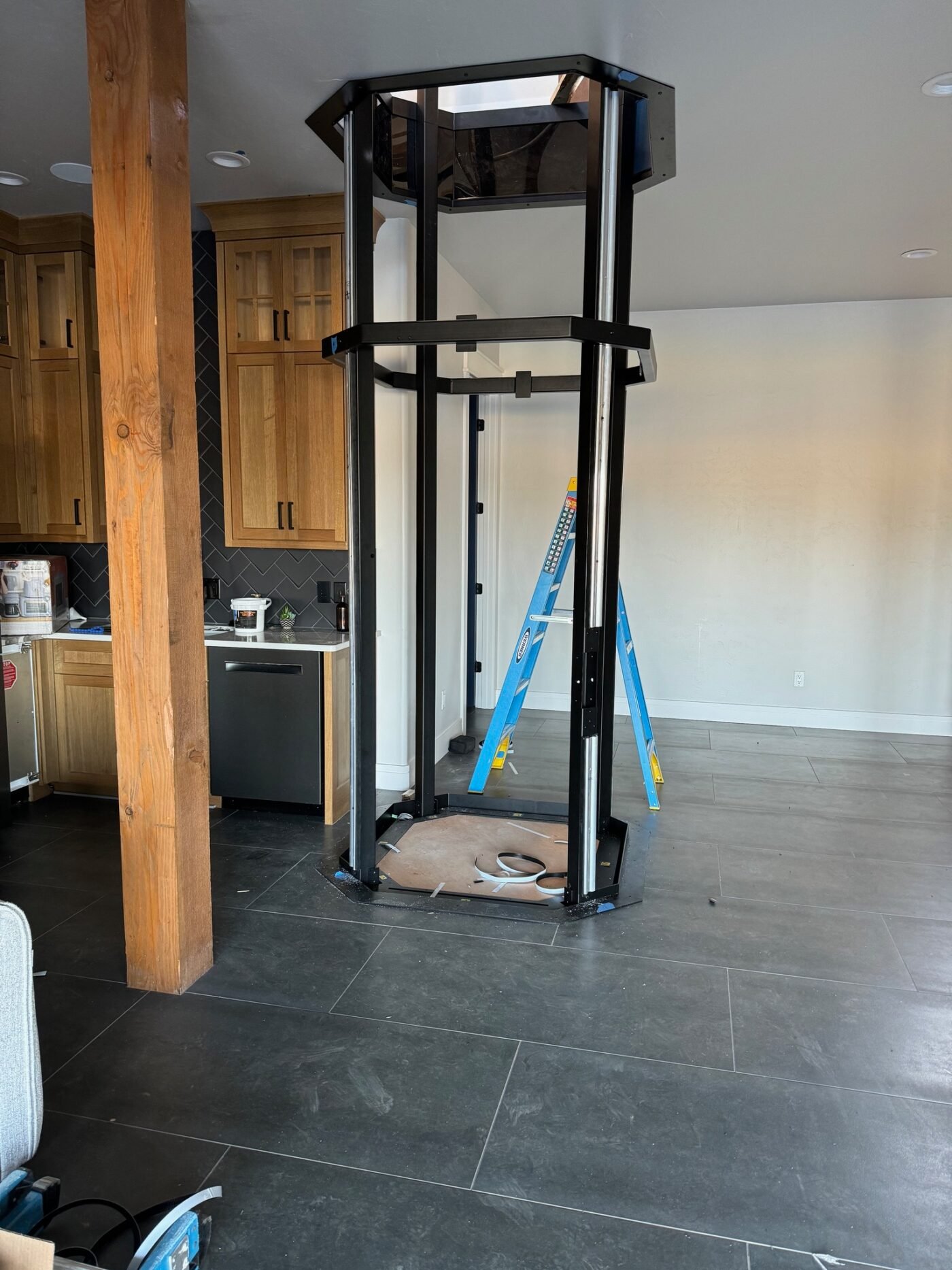 Interior under construction with a timber post and an elevator frame being installed at Cottonwood Creek