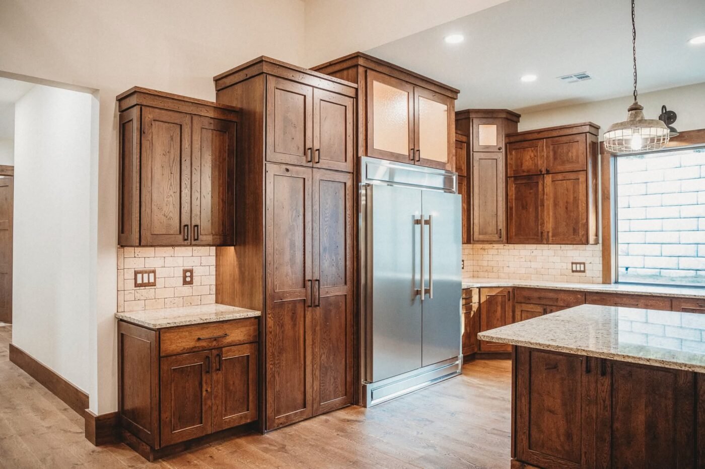 Rustic wood cabinetry and built-in stainless refrigerator at Persimmon Creek Lodge